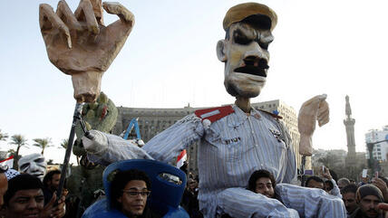 Demonstraters carry a puppet representing Egyptian President Morsi on Cairo's Tahrir Square (photo: Reuters)