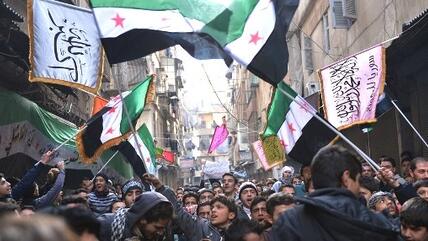Syrian anti-regime protesters wave pre-Baath Syrian flags, now used by the Free Syrian Army, during a demonstration after the weekly Friday prayers in the Bustan al-Qasr district of the northern city of Aleppo on February 8, 2013 (photo: Aamir Qureishi/AFP/Getty Images)