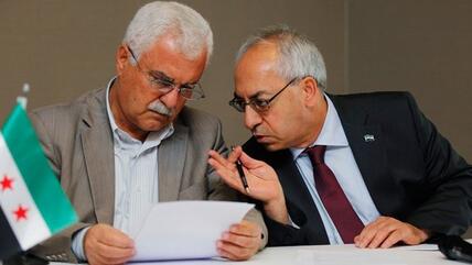 Abdelbasset Sida, leader of the opposition Syrian National Council (R), chats with council member George Sabra during a news conference in Istanbul July 13, 2012 (photo: REUTERS/Murad Sezer)