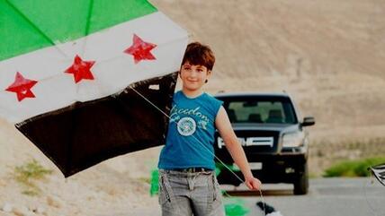 Syrian boy with a kite made from a Syrian Independence flag in the city of Yabroud (photo: DW)