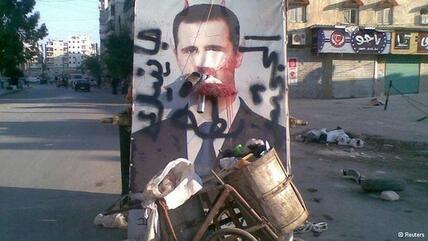 A defaced poster of President Assad in Aleppo (photo: Reuters)