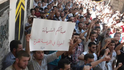 Demonstrators protest against Syria's President Assad after Friday Prayers in Houla on 13 July 2012 (photo: REUTERS/Shaam News Network)