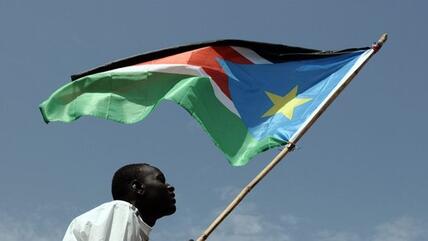 Man holding flag of South Sudan (photo: picture-alliance/dpa)
