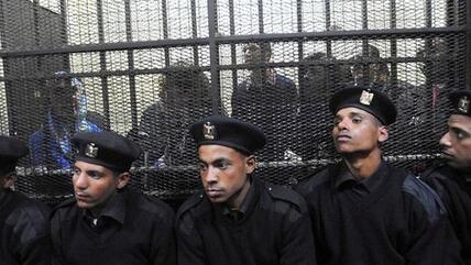 The Foundation's local staff in the Cairo courtroom, behind bars (photo: EPA)