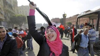 An Egyptian woman sings patriotic songs by herself as she walks along the street outside the Egyptian Museum near Tahrir Square in downtown Cairo, Egypt, Saturday, Feb. 12, 2011 (photo: AP)