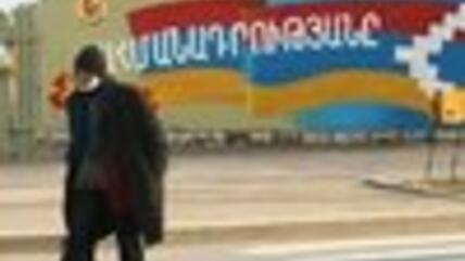 رجل أمام جدار رسم عليه علم جمهورية ناغوني كاراباخ، الصورة: اب