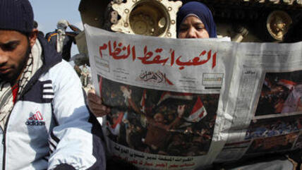 سيدة مصرية تتصفح جريدة الاهرام بهد سقوط مبارك
