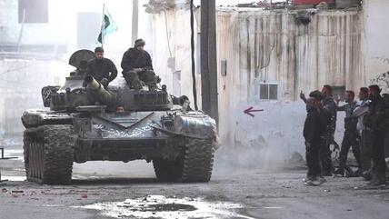 Fighters of the Free Syrian Army driving in a tank through a street near Damascus (photo: Reuters)