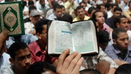 A demonstrator in Tahrir Square holds up a copy of the Koran (photo: AP)