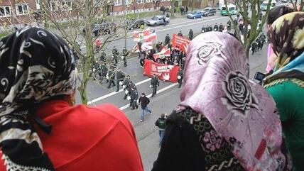 Muslimische Frauen beobachten eine NPD-Demonstration in Duisburg; Foto: AP