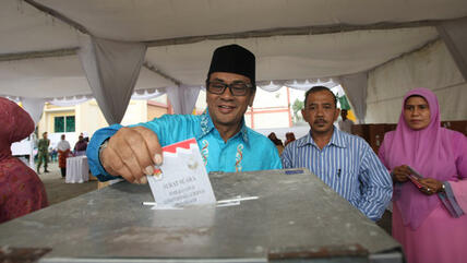 Mawardi Nurdin, one of the mayoral candidates, casts his vote into a ballot box in local elections in Aceh, Indonesia, 9 April 2012 (photo: EPA/Hotli Simanjuntak)