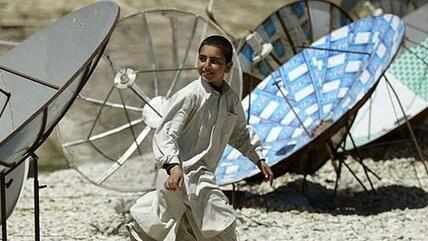 Afghan boy and an array of satellite dishes in Kabul (photo: AP)