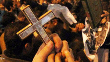 Egyptian Muslims and Christians raise the Quran and Cross in Shobra district, Cairo, Egypt, to protest against the terrorist attack on a Coptic Christian church in the northern Egyptian city of Alexandria, 1 January 2011 (photo: picture-alliance/dpa)