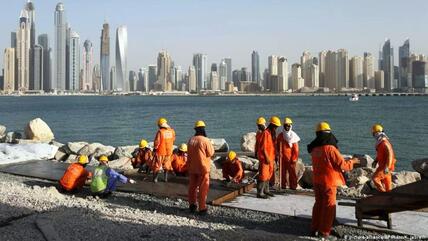 عمال أجانب خلال إقامة إحدى الجزر الصناعية في دبي التي تشكل نموذجا لدورهم في إعمار بلدان الخليج دون تمتعهم بحقوق أساسية