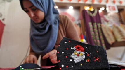 A Palestinian woman works on Christmas-themed masks in Gaza City on 9 December 2020.