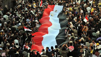 Yemeni people wave a national flag during a celebration commemorating the third anniversary of the 2011 uprising in Sanaa, Yemen, 11 February 2014. 