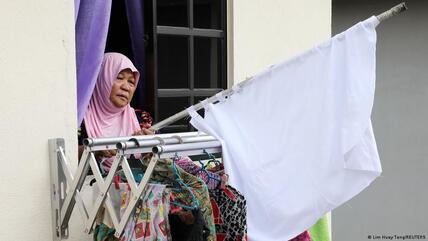 Halijah Naemat, 74, puts away a white flag after she received help from others at her home during an enhanced lockdown, amid the coronavirus disease (COVID-19) outbreak, in Petaling Jaya, Malaysia, 6 July 2021.