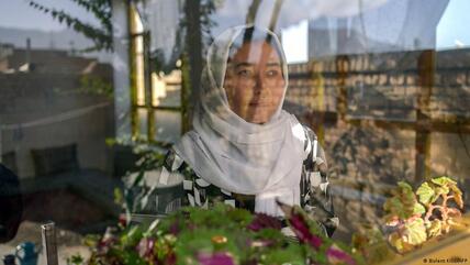 تلميذة أفغانية تنظر من النافذة - أفغانستان.