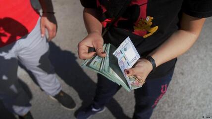 امرأة تحصي نقودها في لبنان.
