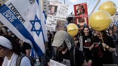 People holding yellow balloons, Israeli flags and pictures of relatives take part in a protest march to free Israeli hostages held by Hamas