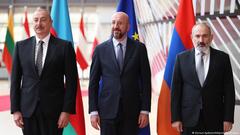 President of Azerbaijan Ilham Aliyev, President of the European Council Charles Michel and  Prime Minister of Armenia Nikol Pashinyan stand in suits in front of their respective flags