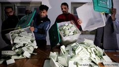 Polling staff empty a ballot box after polls closed at a polling station during the general election, in Lahore, Pakistan