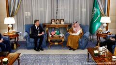 US Secretary of State Antony Blinken (left) and Saudi Arabia's Foreign Minister Prince Faisal bin Farhan Al-Saud (right) sit in blue armchairs on either side of a small table with the American and Saudi flags, during their meeting in Jeddah, Saudi Arabia, 20 March 2024 
