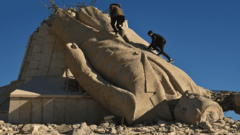 Zwei Männer klettern auf eine in Trümmern liegende Statue