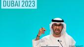 Wearing traditional Arab dress and standing against a turquoise background, Sultan Ahmed Al Jaber, president of this year’s COP28, gives the opening address