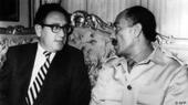 U.S. Secretary of State Henry Kissinger (left) sits on an ornate sofa with Egyptian President Anwar Sadat