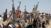 Houtji supporters hoist weapons and shout slogans against the U.S. and UK