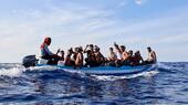 Migranten in einem Fischerboot über dem Mittelmeer.