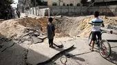 Kinder stehen an einem Bombenkrater in Rafah