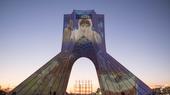 Das Portrait einer Krankenschwester im Schutzanzug wird auf das Azadi-Denkmal in Teheran projiziert.