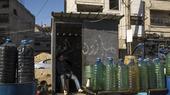 Ein Mann verkauft auf der Straße in Syrien Treibstoff aus Plastikflaschen.