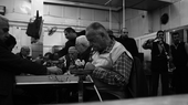 Ein Mann sitzt in einem Café, das Foto ist schwarz-weiß