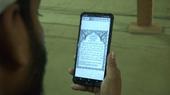 Ein Mann liest den Koran auf seinem SmartPhone.