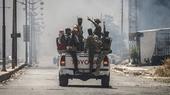 A Toyota truck carrying a group of armed and masked fighters.