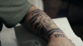 Ein Unterarm eines jungen Mannes mit einem Tattoo