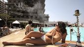 A woman is smoking a hookah by a swimming pool. (Photo: Promo/Patrick Baz)