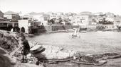 Black and white image of the Beirut seafront, with a sailing boat in the centre.