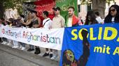 A group of people are holding banners bearing the words "Don't Forget Afghanistan"