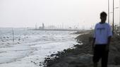 A coastline with a man blurred in the foreground.