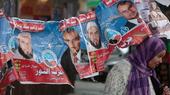 An Egyptian woman passes under electoral posters with pictures of candidates of the Salafist Al-Nour party (photo: AP/dapd)