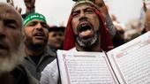 Anhänger Mohammed Mursis hält während einer Demonstration in Kairo den Koran hoch; Foto: AFP/Getty Images