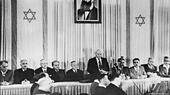 مايو / أيار 1948 - ديفيد بن غوريون (واقفاً) يعلن استقلال دولة إسرائيل في تل أبيب.
