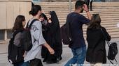سيدة إيرانية محجبة تنظر إلى شابة غير مرتدتة الحجاب الإلزامي - معرض الكتاب الدولي عند مسجد الإمام الخميني الكبير وسط طهران - 14 مايو / أيار 2023.