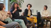 Five people (including, from left, Tom Kellner, Seba Abu Daqa, Gali Blay and Elisha Baskin) sit on chairs in a room; one is talking, all others are looking at her