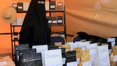 A woman wearing a black hijab and face veil displays products at a fair organised to promote locally grown coffee in Sanaa, Yemen, 3 March 2024