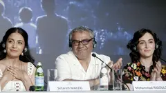 Regisseur und zwei Schauspierinnen bei einer Pressekonferenz in Cannes, 2024.